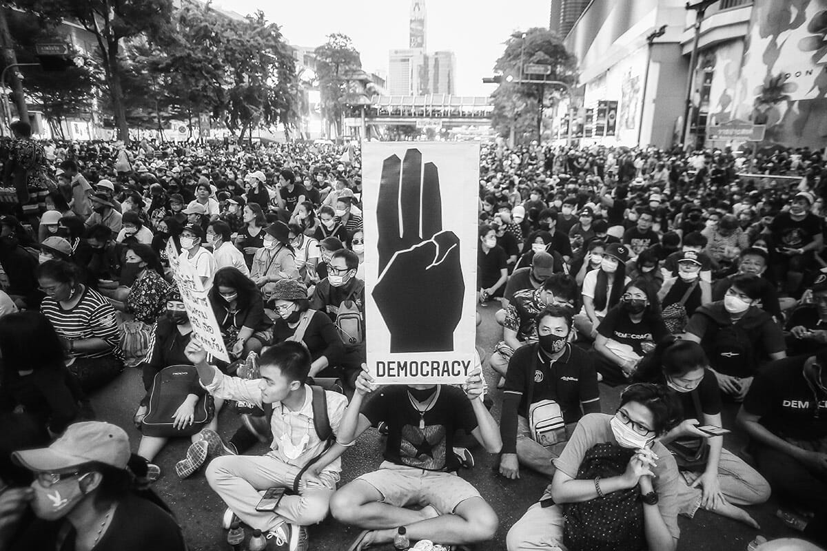 Bangkok, October 2020. Pro democracy protestors gather in Bangkok. Photo:  kan Sangtong / Shutterstock.com<br />
Above: Students sit in the middle of the street to protest. Photo: Rungkh / Shutterstock.com

